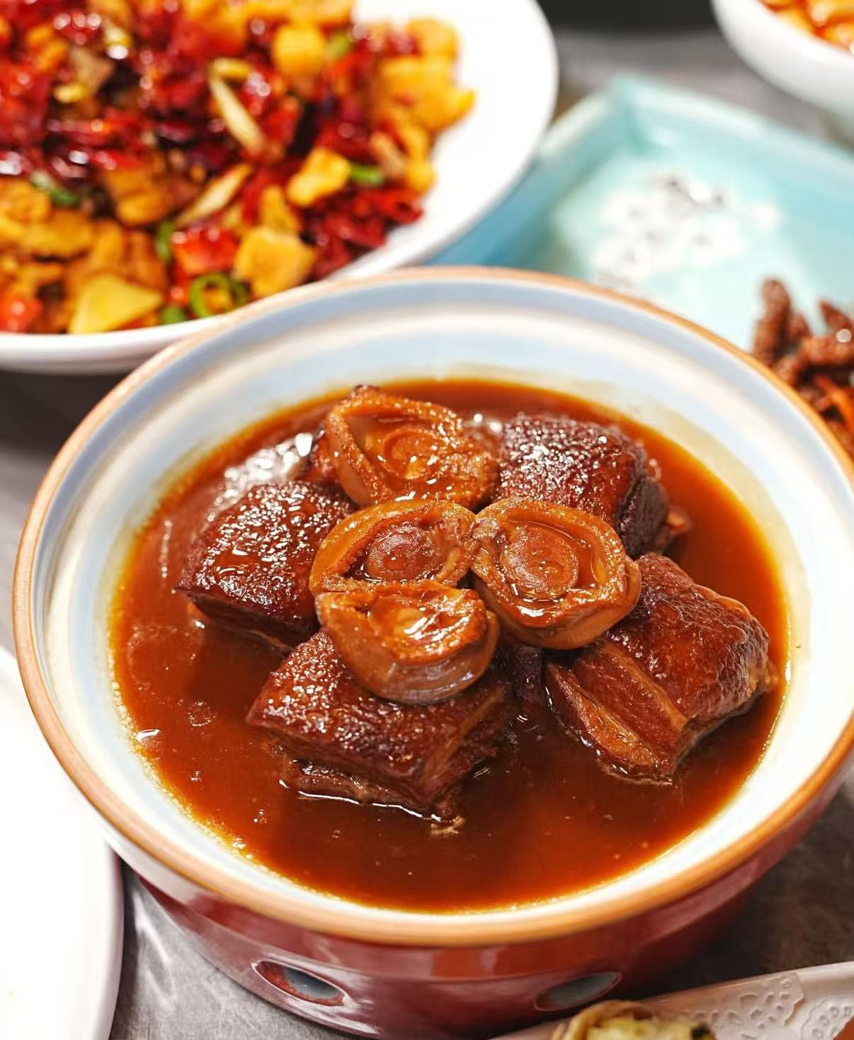 Braised pork dish in a bowl with sauce and side dishes